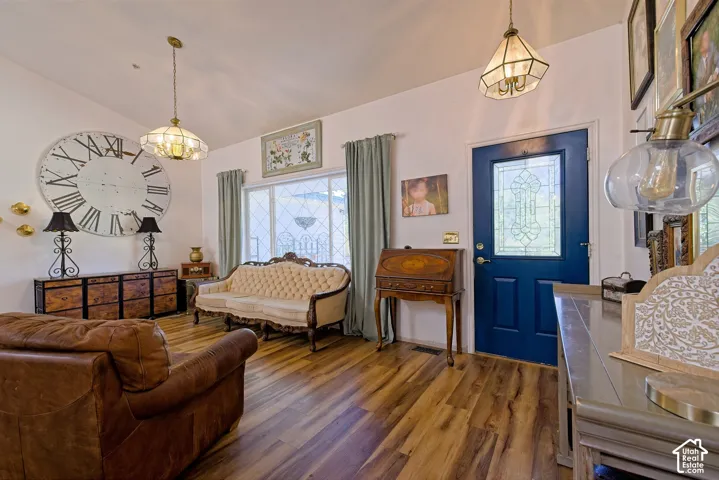 Wood-finish flooring throughout, featuring a paneled entry door with decorative glass