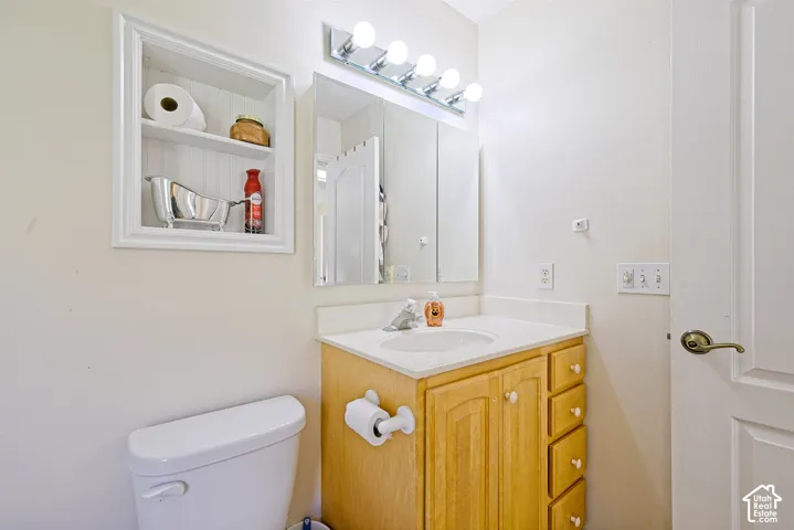 Light-toned wood vanity with a white countertop, featuring an integrated sink with a chrome faucet