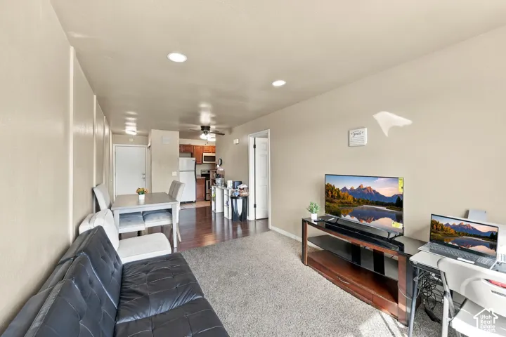 Open-concept living area with recessed lighting, dark wood-finish flooring, and a dining space