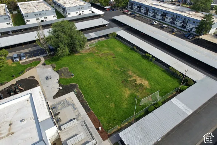 Expansive grassy area surrounded by concrete pathways and mature landscaping
