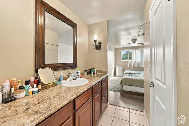 Bathroom vanity featuring a single basin, stone-look countertop, and wood-finish cabinetry