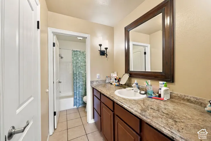 Spacious vanity with a light-toned countertop and an integrated sink, complemented by a large framed mirror and dark wood cabinetry