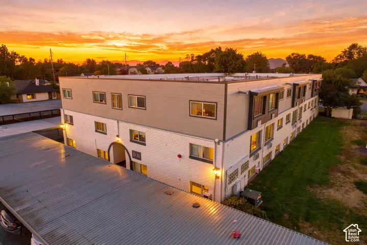 Multi-story building featuring a two-tone exterior, multiple windows, and exterior lighting fixtures