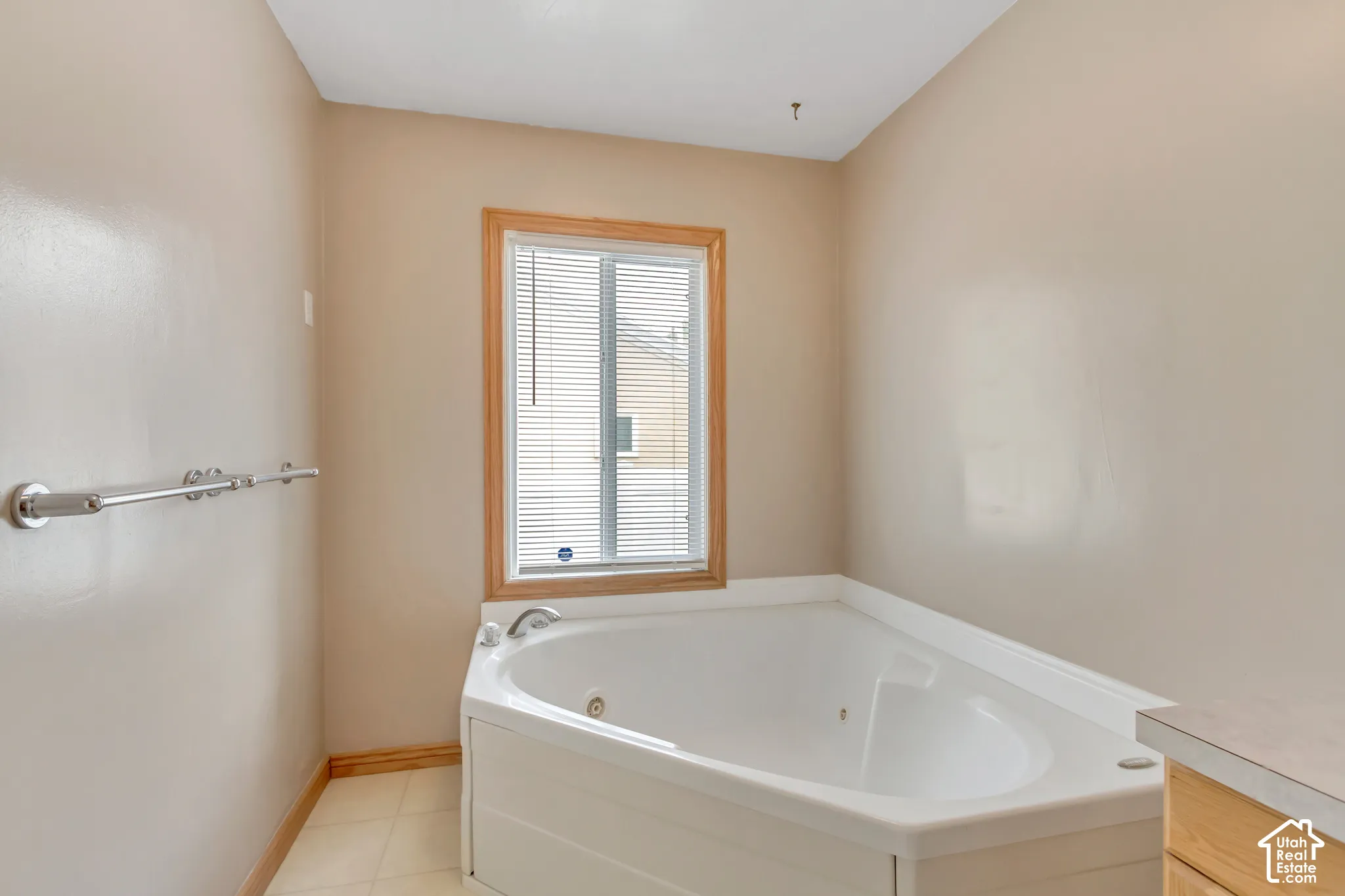 Corner soaking tub with a window and wood trim