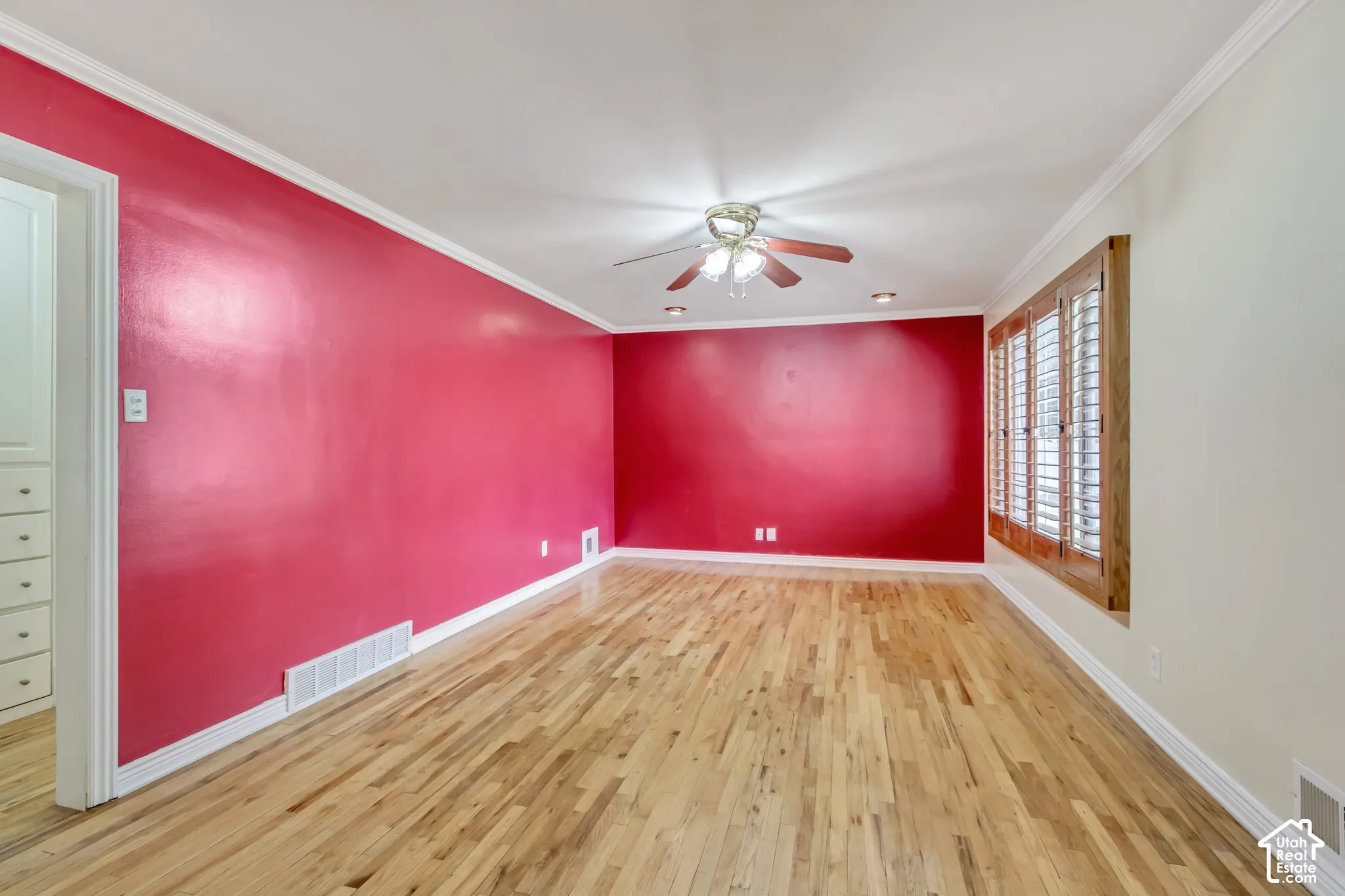 Wood-finish flooring, ceiling fan with integrated lighting, recessed lighting, crown molding, and wood plantation shutters