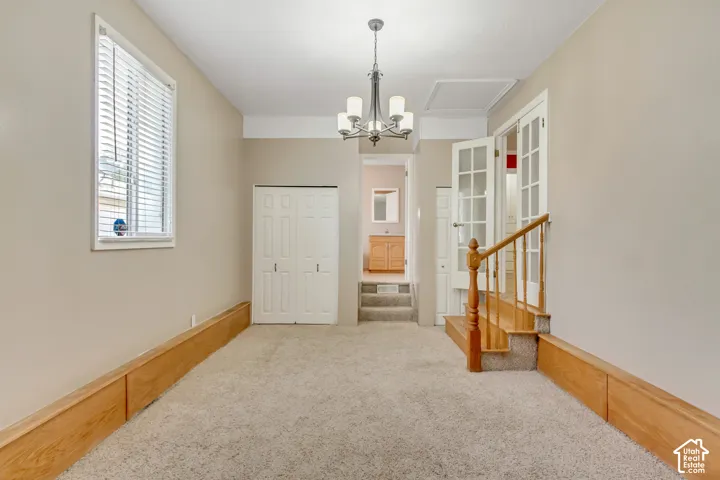 Recessed lighting, wood-finish wall paneling, and a classic chandelier fixture