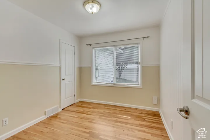 Hardwood flooring, painted walls, white trim, recessed window, and flush mount lighting