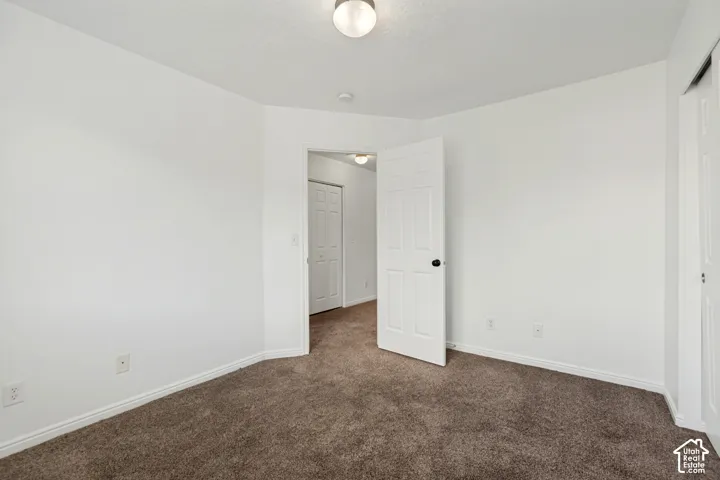 Carpeted flooring, white interior doors, and a ceiling-mounted light fixture