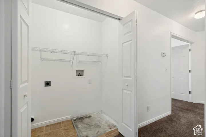 Laundry area featuring tile flooring, bi-fold doors, and built-in wire shelving