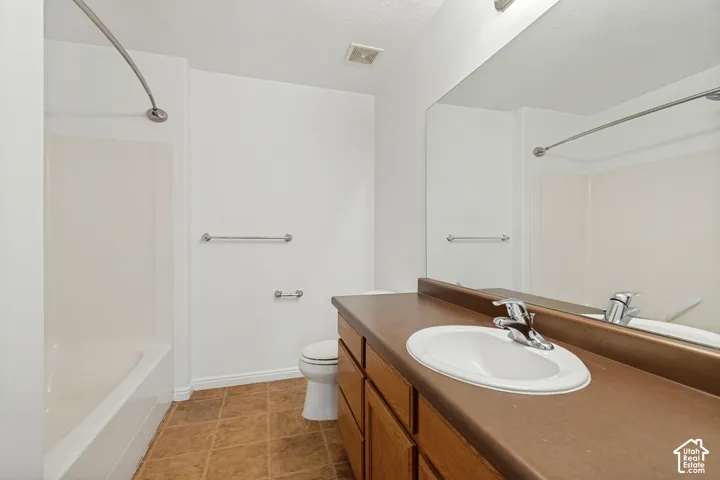 Integrated vanity with wood-finish cabinetry, a single basin sink, and a large wall-mounted mirror