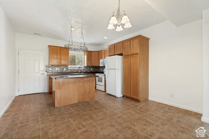 Expansive kitchen featuring wood-finish cabinetry, a large kitchen island, tiled flooring, and a decorative tile backsplash