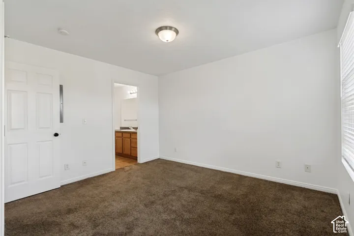 Carpeted room with white walls, a flush-mount ceiling light, and a window with blinds