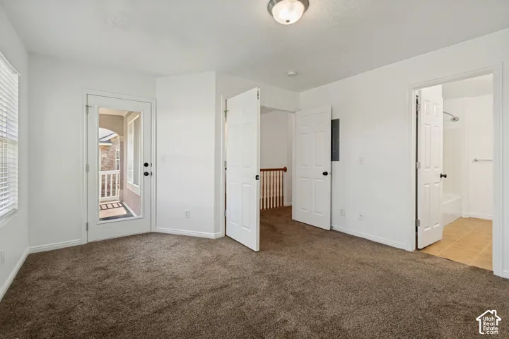 Brown carpet flooring, white walls, and a glass-paneled door