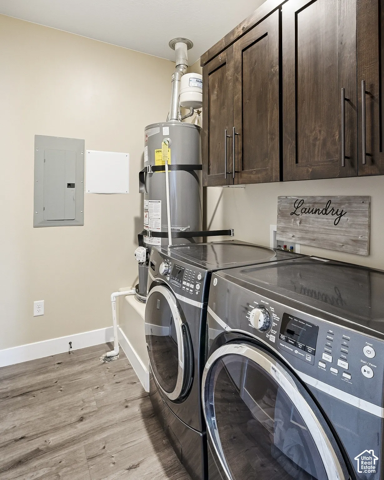 Dark wood-finish cabinetry, wood-finish flooring, and a water heater installation