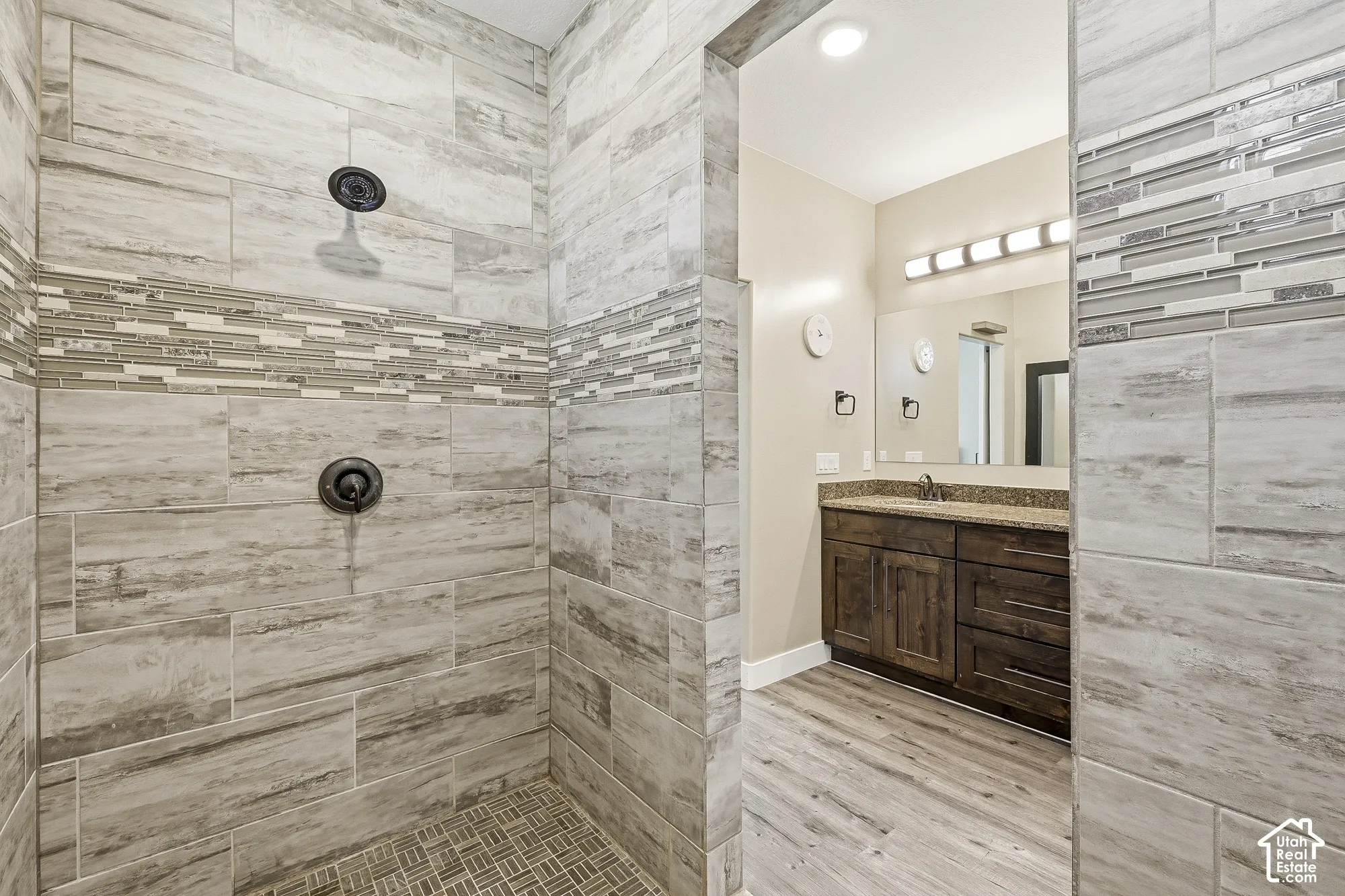 Walk-in shower with large format tile and mosaic accent band