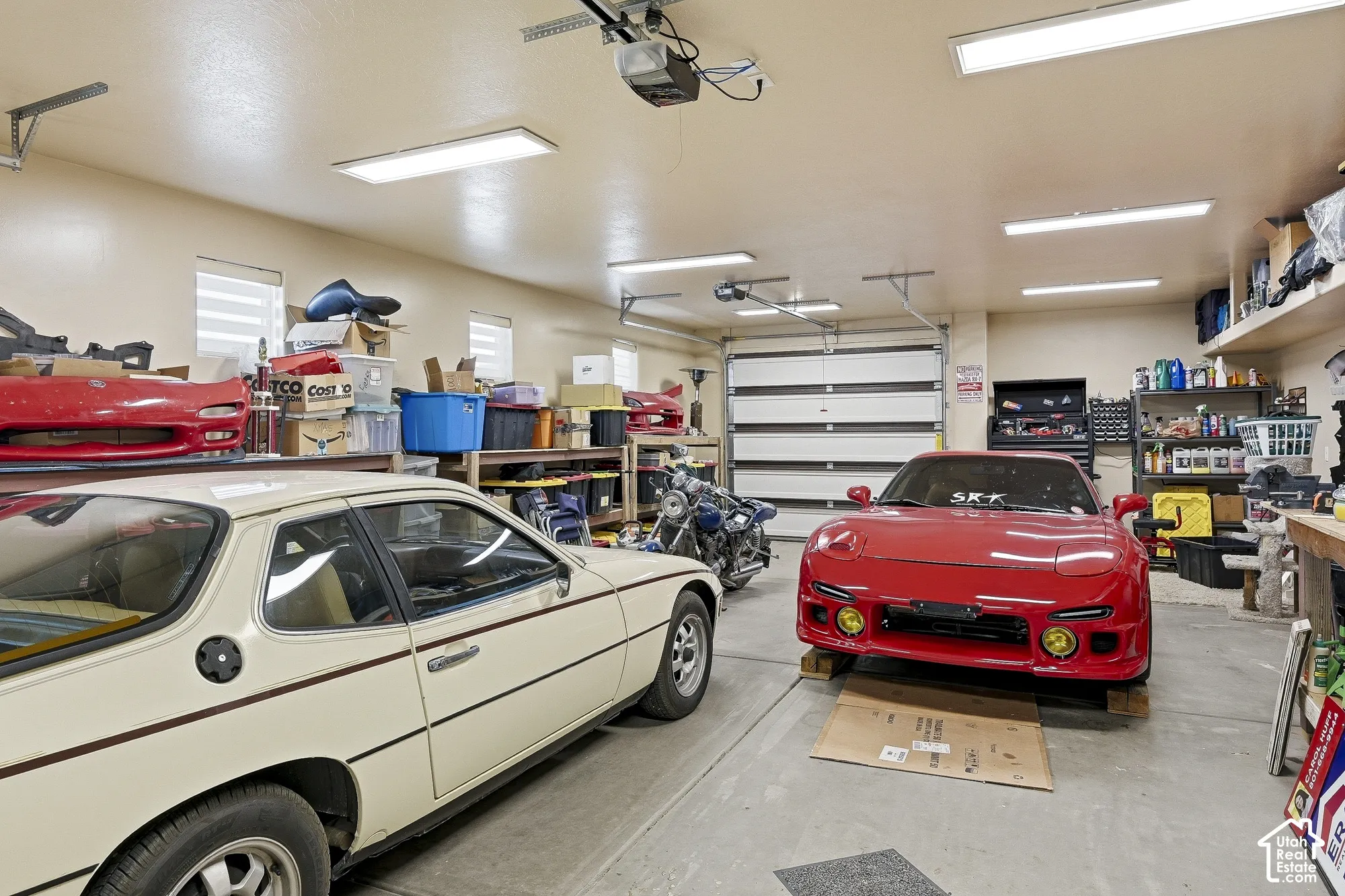 Two-car garage featuring automatic overhead doors, multiple windows, and overhead lighting