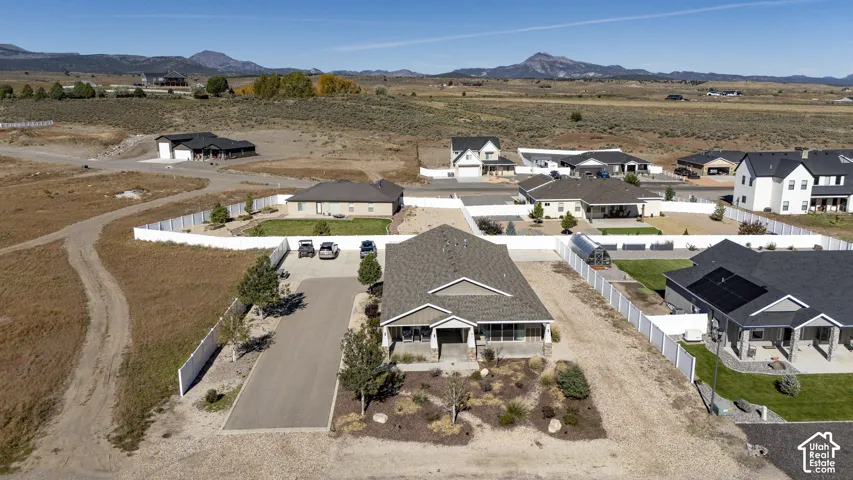 Newly constructed home with a covered front porch, paved driveway, and mature landscaping