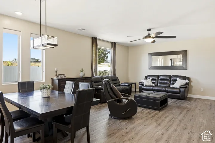 Open-concept living area featuring wood-finish flooring, recessed lighting, and a ceiling fan