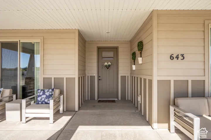 Covered concrete porch with horizontal siding and vertical paneling