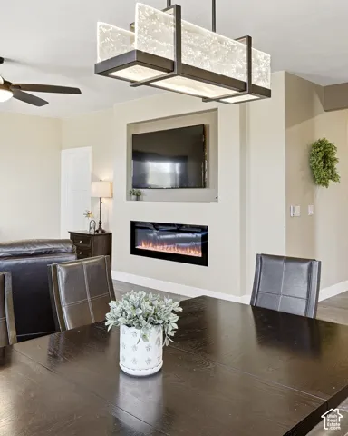 Built-in electric fireplace and media niche, overhead decorative lighting fixture, and wood-finish flooring
