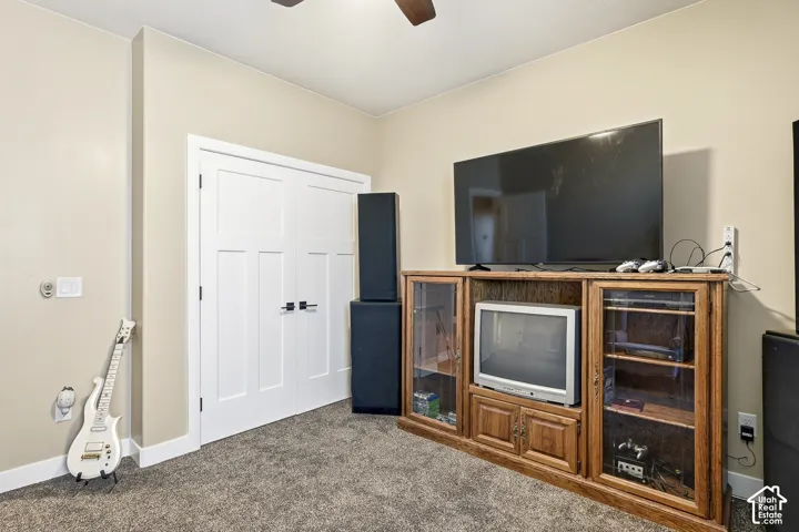 Built-in wood-finish media console with glass-front display cabinets, light neutral wall paint, and white trim
