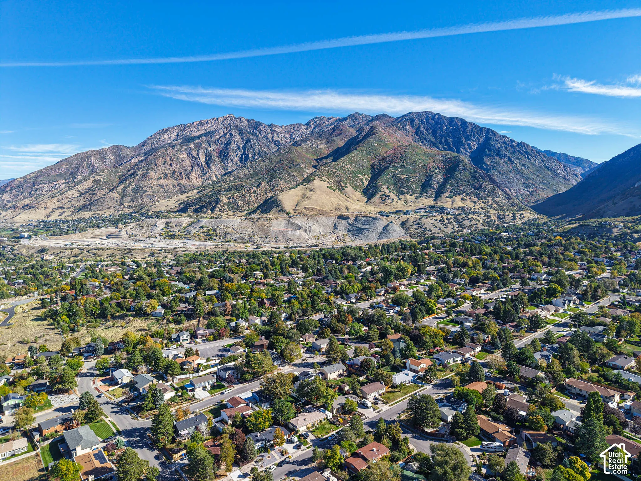 Expansive mountain backdrop with a residential area featuring mature trees and established streets