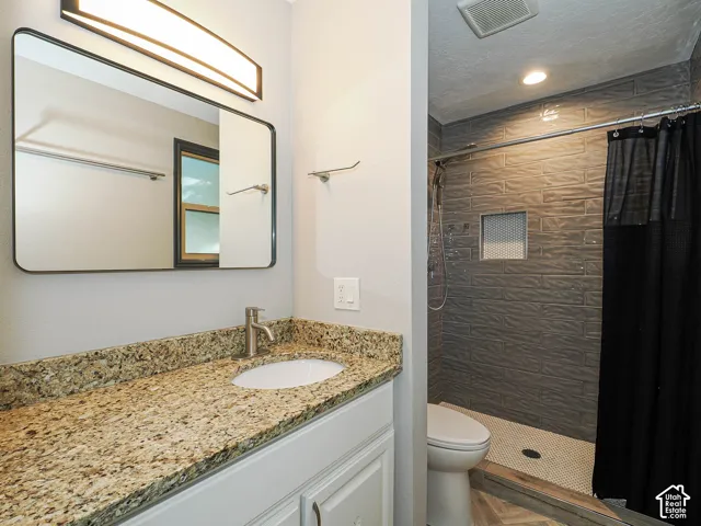 Vanity with a speckled countertop, undermount sink, and brushed nickel faucet