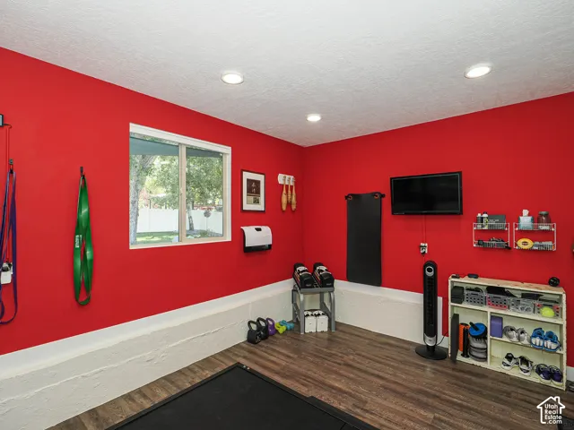 Room featuring wood-finish flooring, recessed lighting, and a window with white trim
