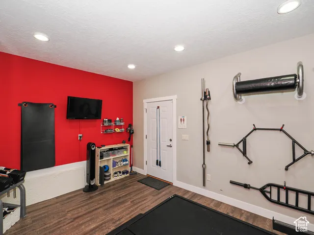 Recessed lighting, wood-finish flooring, white trim, and a white paneled door