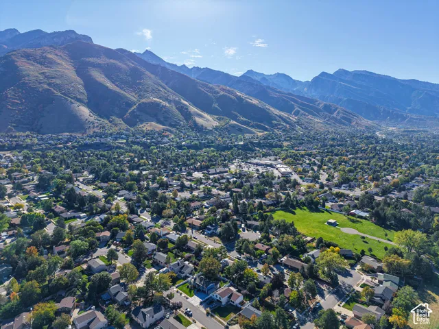 Expansive neighborhood featuring residential properties, mature trees, and mountainous terrain