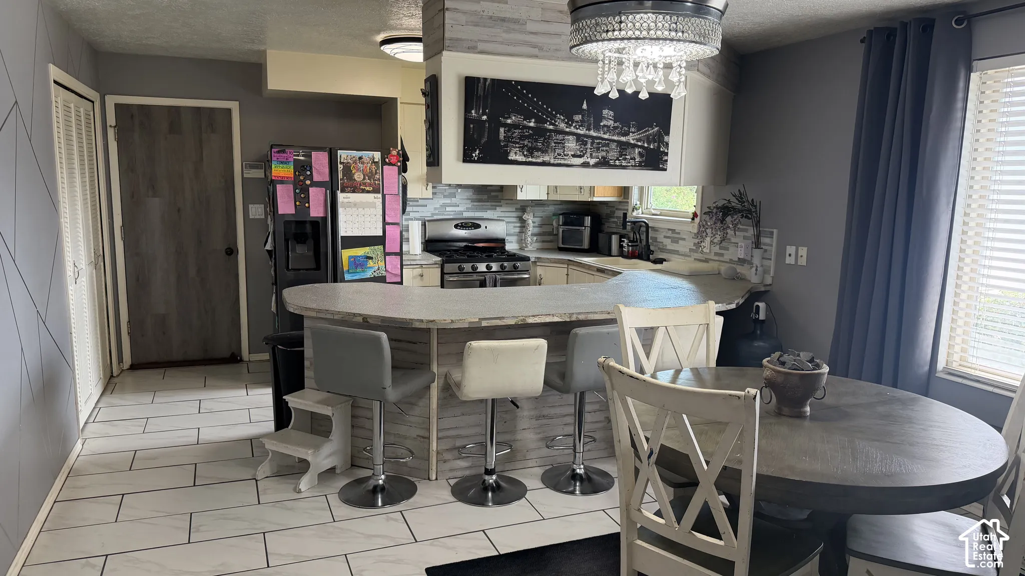 Breakfast bar , fridge, gas range and dining area