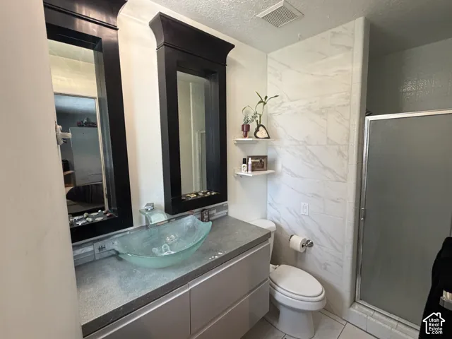 Bathroom 1- Dual framed mirrors, vessel sink, vanity with storage and glass-enclosed shower