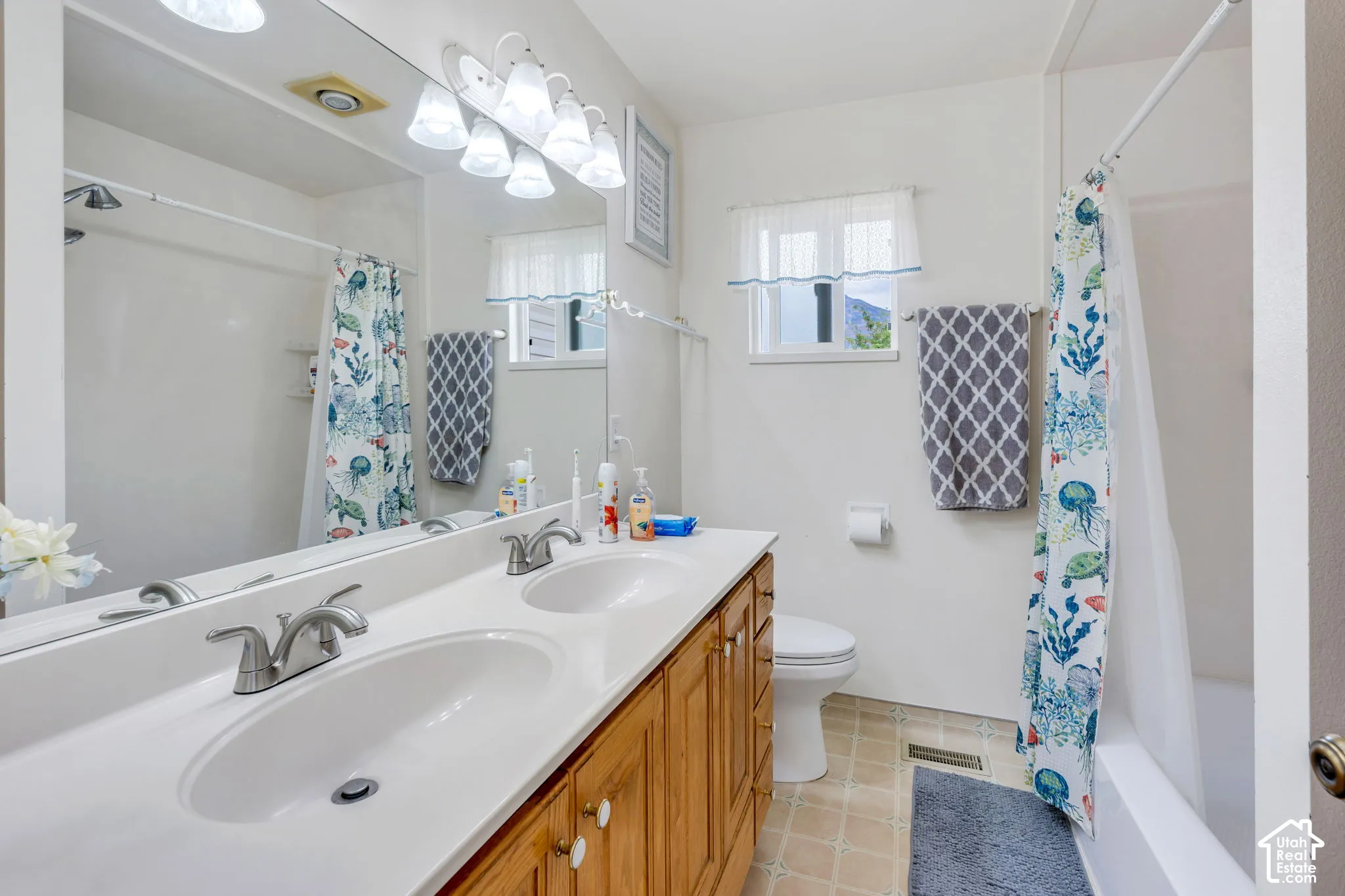 Dual vanity with wood-finish cabinetry, integrated sinks, and brushed nickel faucets