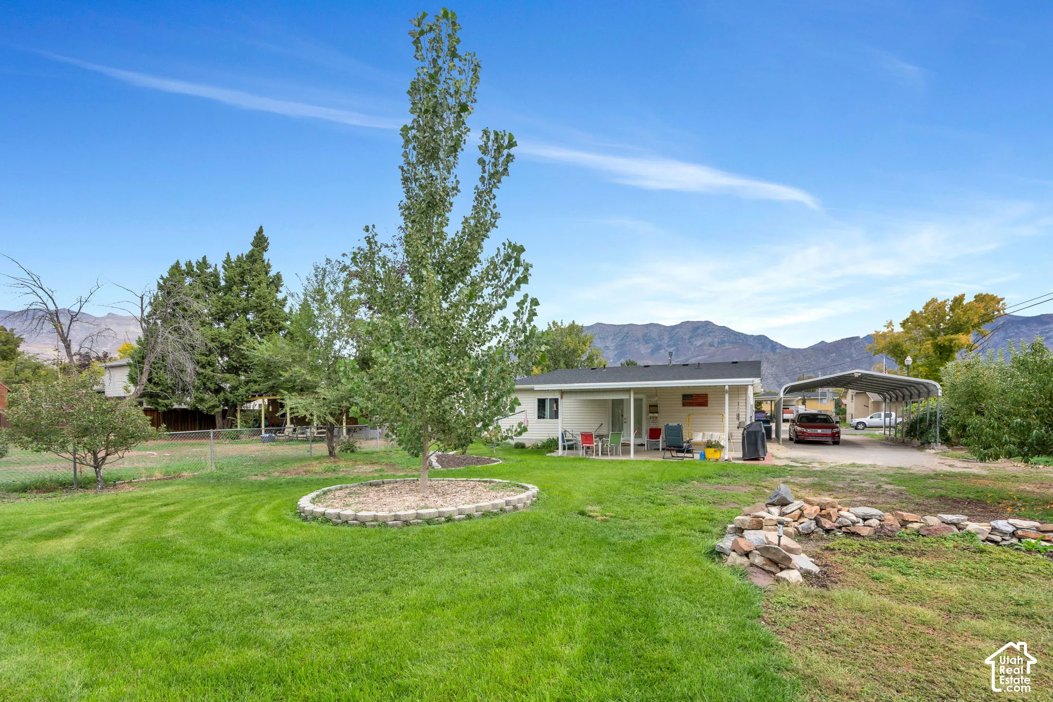 Expansive rear yard featuring a manicured lawn and mature trees