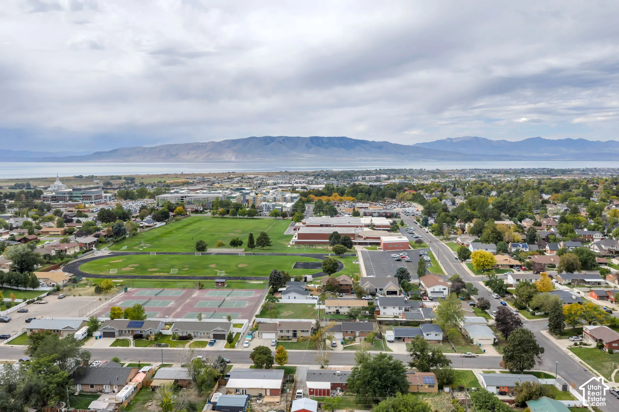 Aerial perspective showcasing a residential area with established landscaping, open green spaces, and sports courts