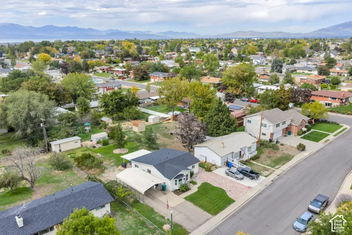 Expansive residential neighborhood featuring detached homes, mature trees, and mountainous terrain in the distance