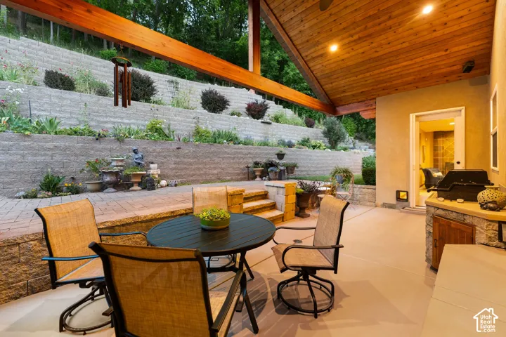 Covered patio featuring a wood-plank ceiling, exposed wood beams, and recessed lighting