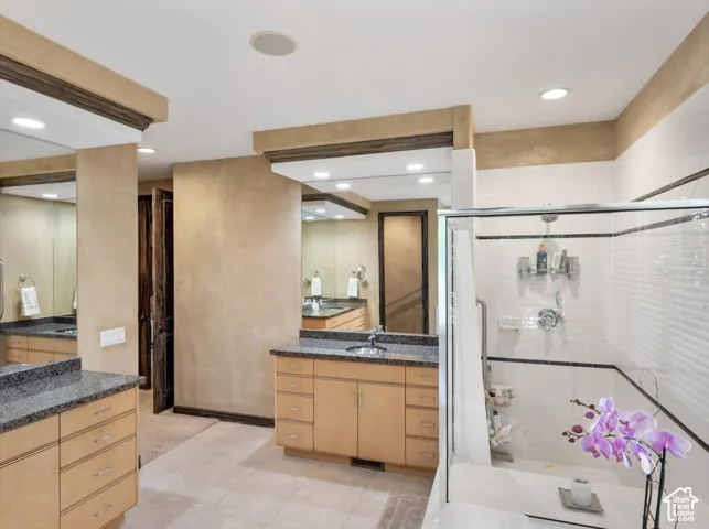 Dual vanity sinks with granite countertops and light wood cabinetry