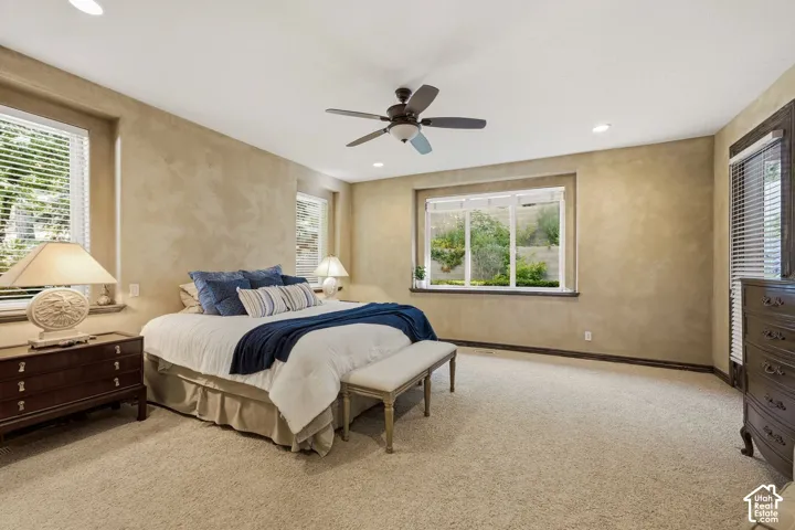 Recessed lighting, ceiling fan, multiple windows, textured wall finish, and carpeted flooring