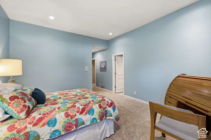 Recessed lighting, light blue wall paint, and carpeted flooring