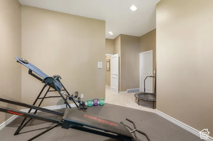 Dedicated exercise space with neutral wall tones and recessed lighting