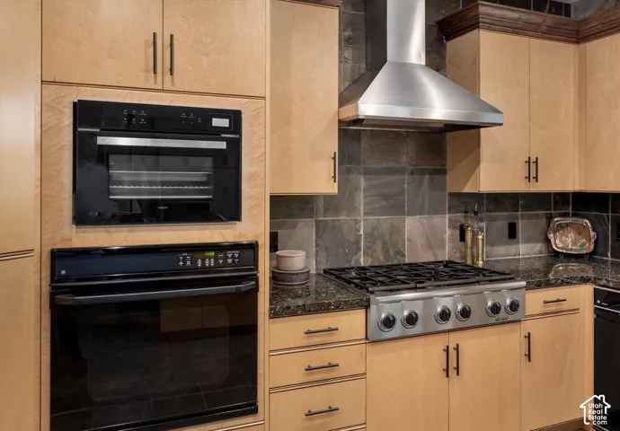 Built-in stainless steel double oven, gas range with stainless steel hood, and granite countertops