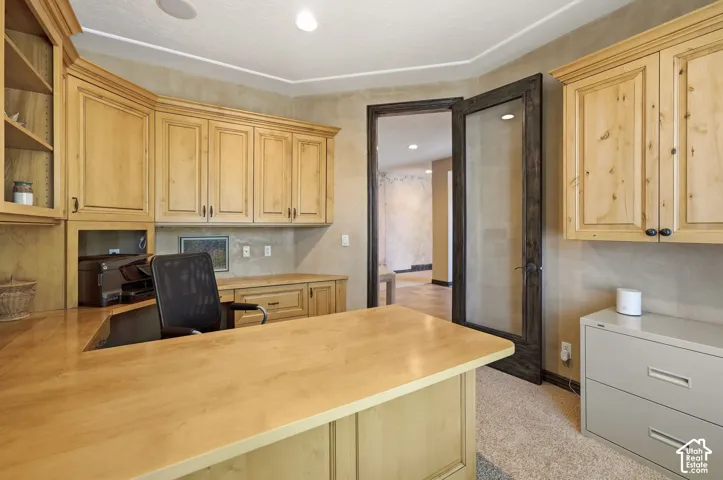 Built-in wood-finish cabinetry, integrated desk, and glass-paneled entry door