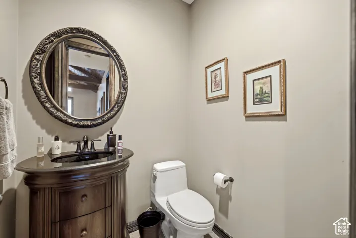 Wood-finish vanity with an oval basin, dark countertop, and oil-rubbed bronze faucet