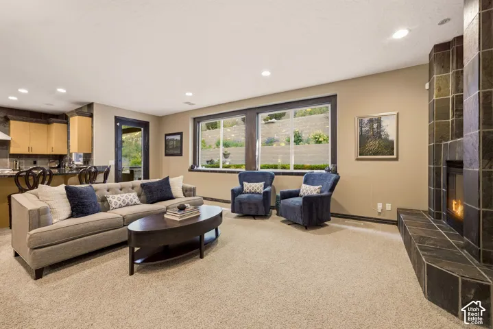 Open-concept living space featuring a tile-clad fireplace, recessed lighting, and a large window