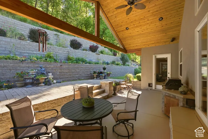 Expansive covered patio with a wood-finish vaulted ceiling and ceiling fan