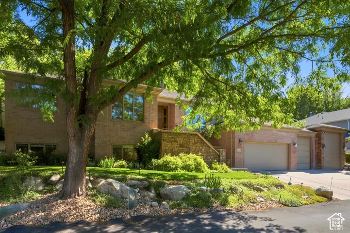 Brick exterior with multiple windows, stone accents, and an attached multi-car garage