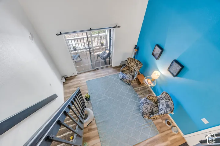 Wood-finish flooring with a contrasting accent wall, complemented by a sliding glass door leading to an outdoor balcony