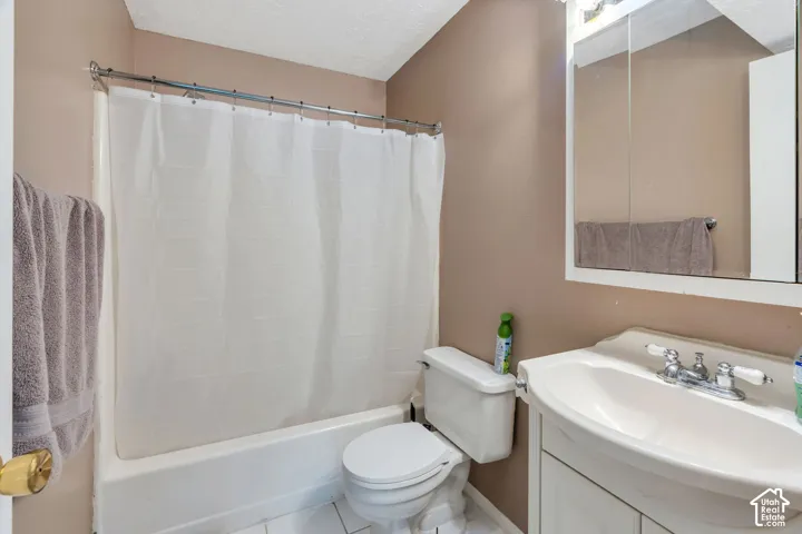 Full bathroom featuring a white vanity with integrated sink, chrome faucet, wall-mounted medicine cabinet, and a shower/tub combination