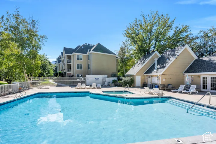 Outdoor swimming pool with integrated spa, surrounded by a concrete deck